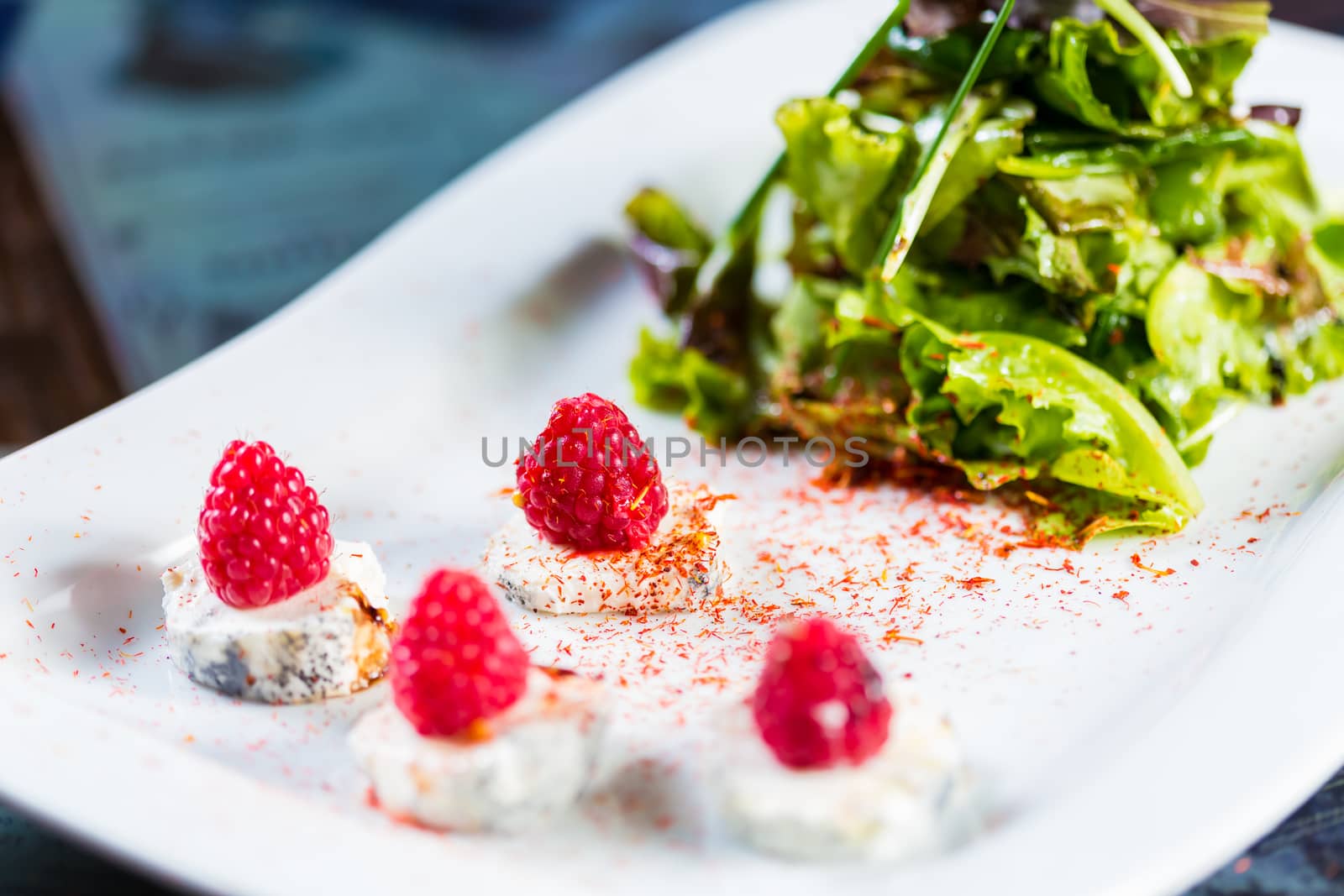 fresh salad with goat cheese and raspberry. Healthy Food