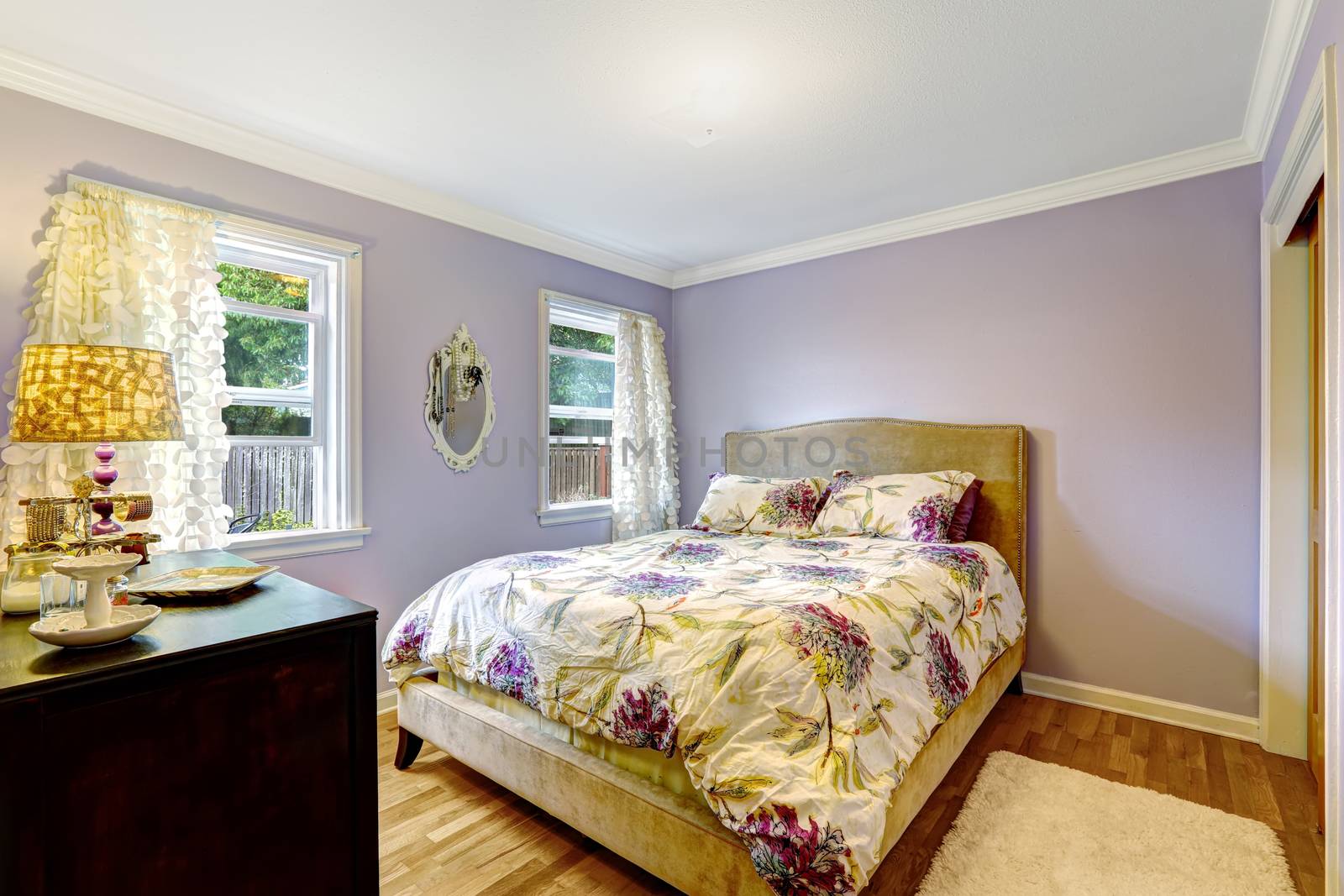Bedroom in light lavender color with ivory floral bedding