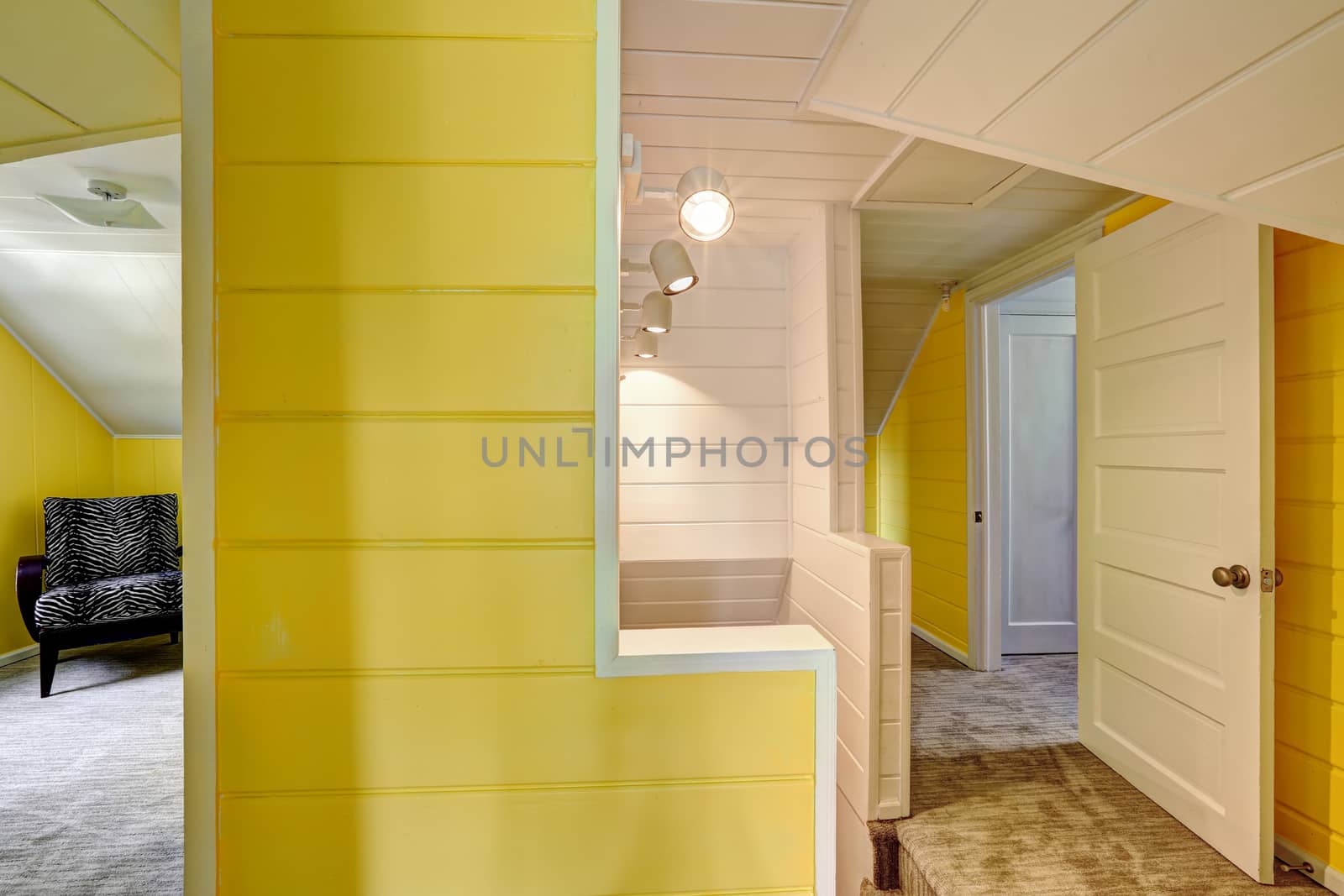 Upstairs hallway with bright yellow wall and plank trim