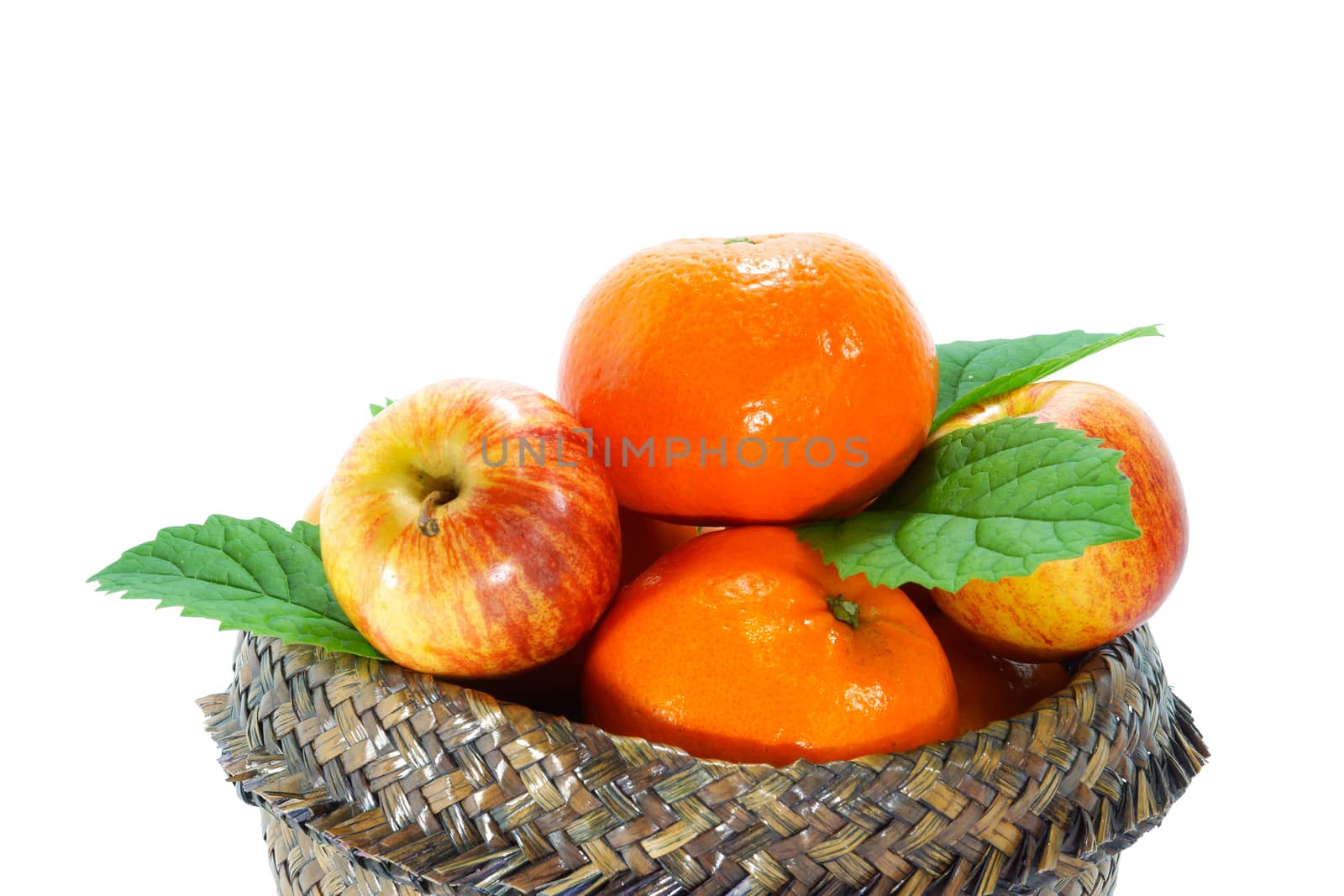 Orange, apple and persimmon in the basket of papyrus.