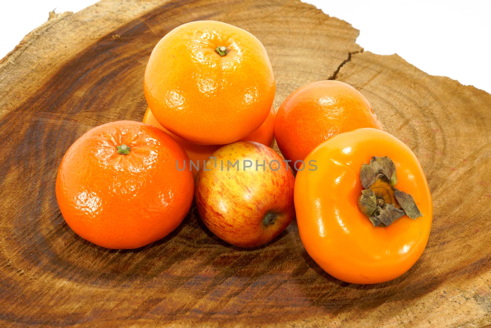 Orange, apple and persimmon on the wood