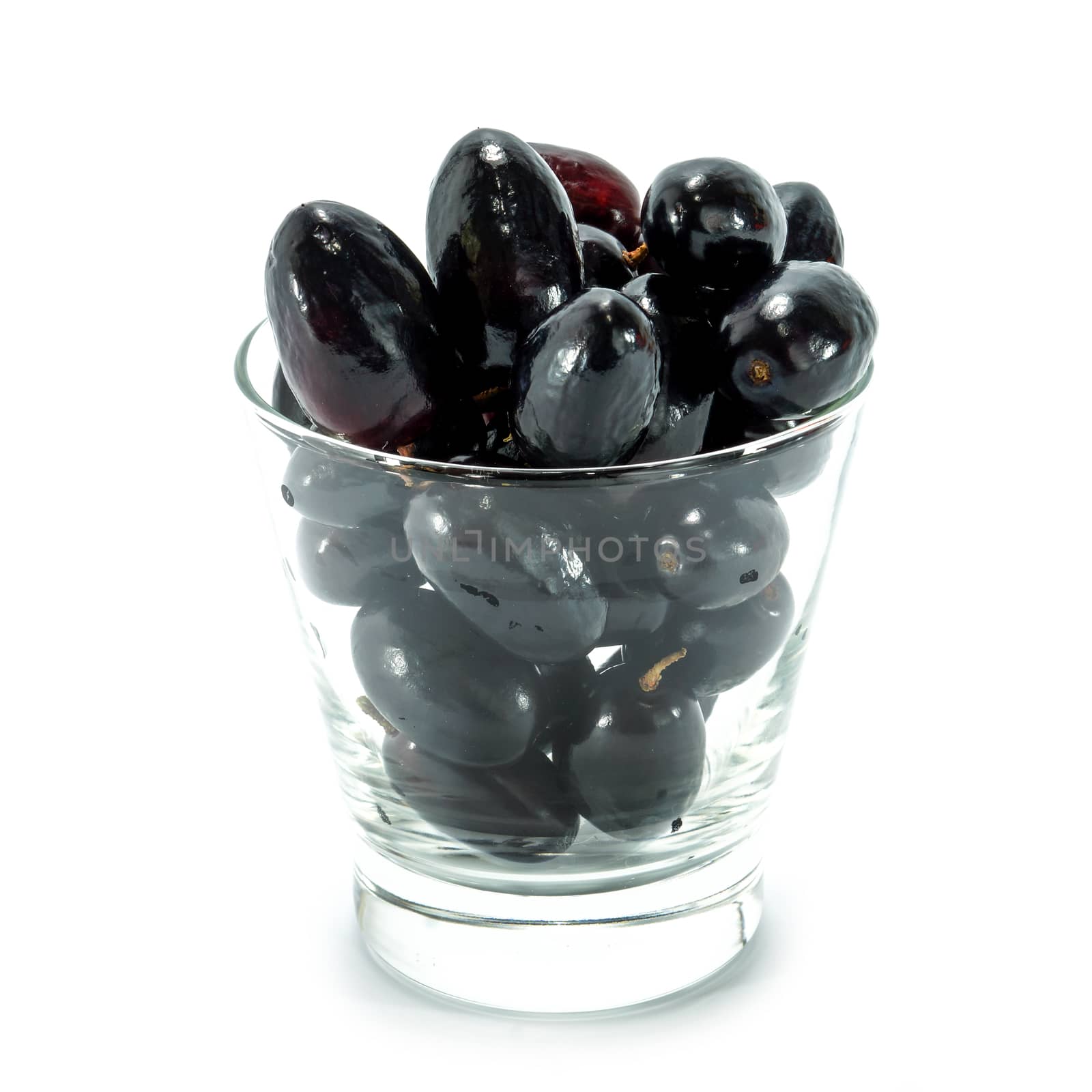 Black grapes in a glass isolated on a white background. by Noppharat_th