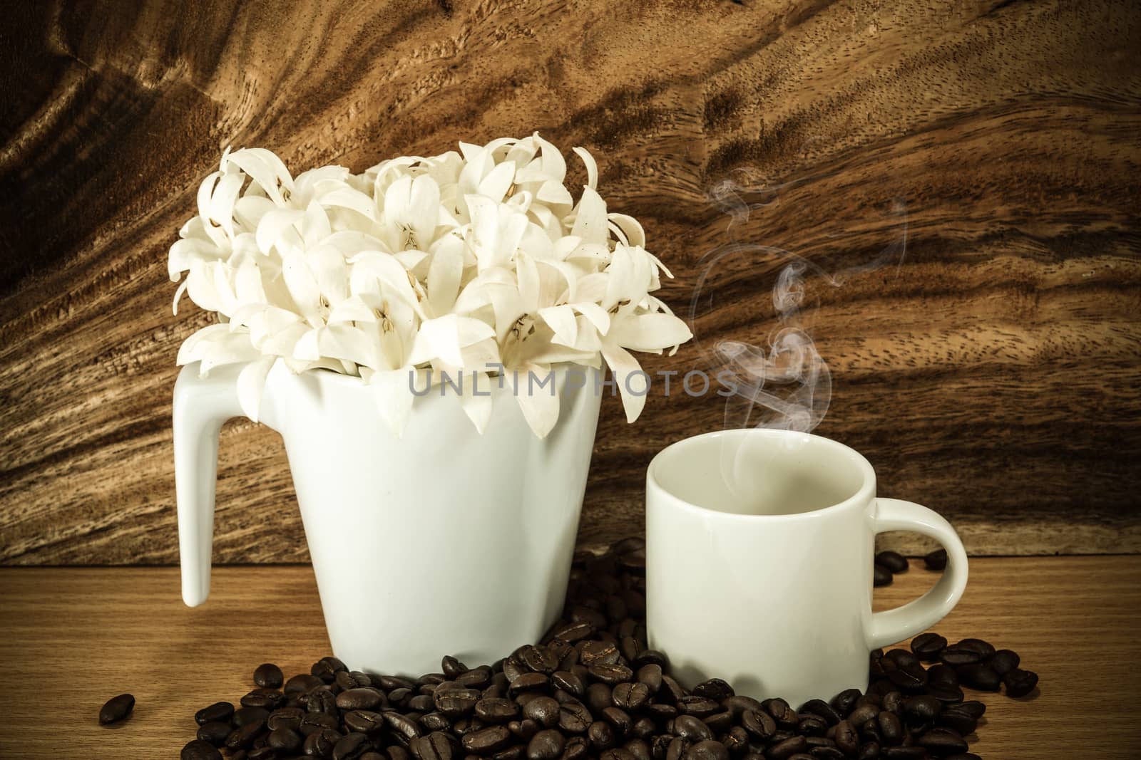 Fragrant white flowers in a glass (Indian cork tree, scientific name: Millingtonia hortensis Linn.f) on wooden background.
