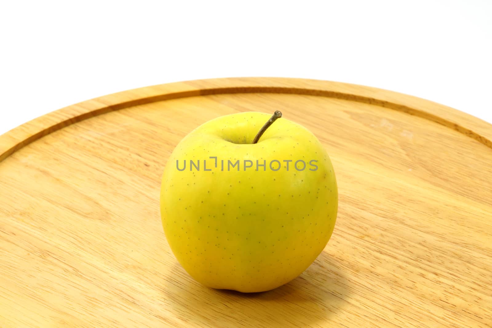 Yellow apple on wood