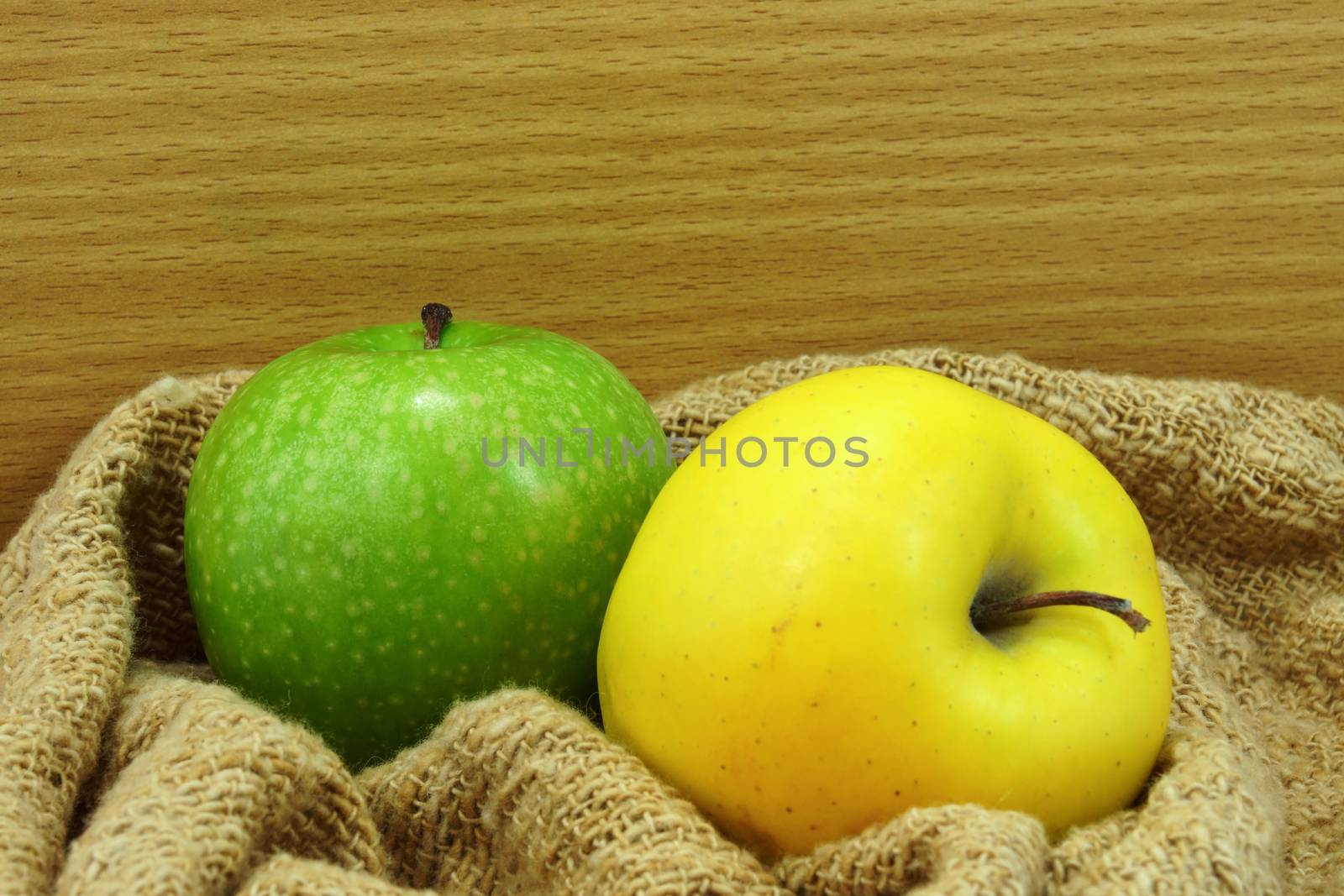 Yellow and green apple on fabric. by Noppharat_th