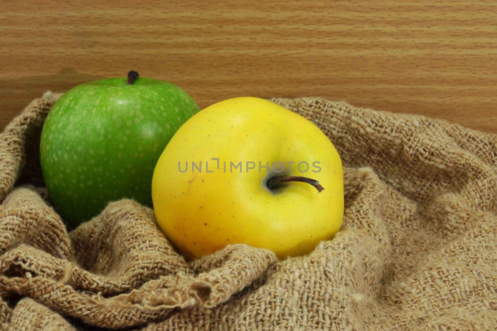 Yellow and green apple on fabric.