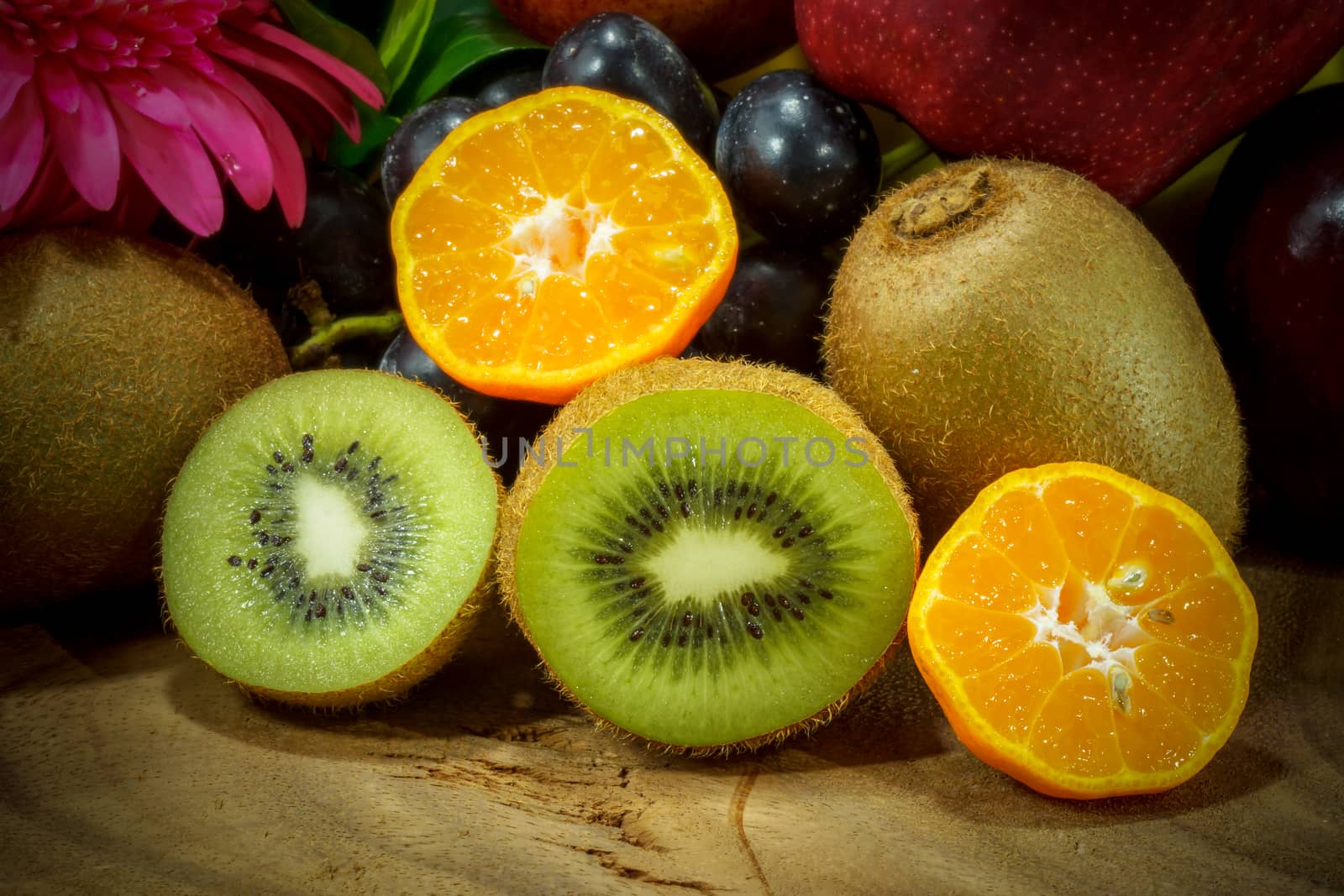 Assortment of exotic fruits on wood background. by Noppharat_th