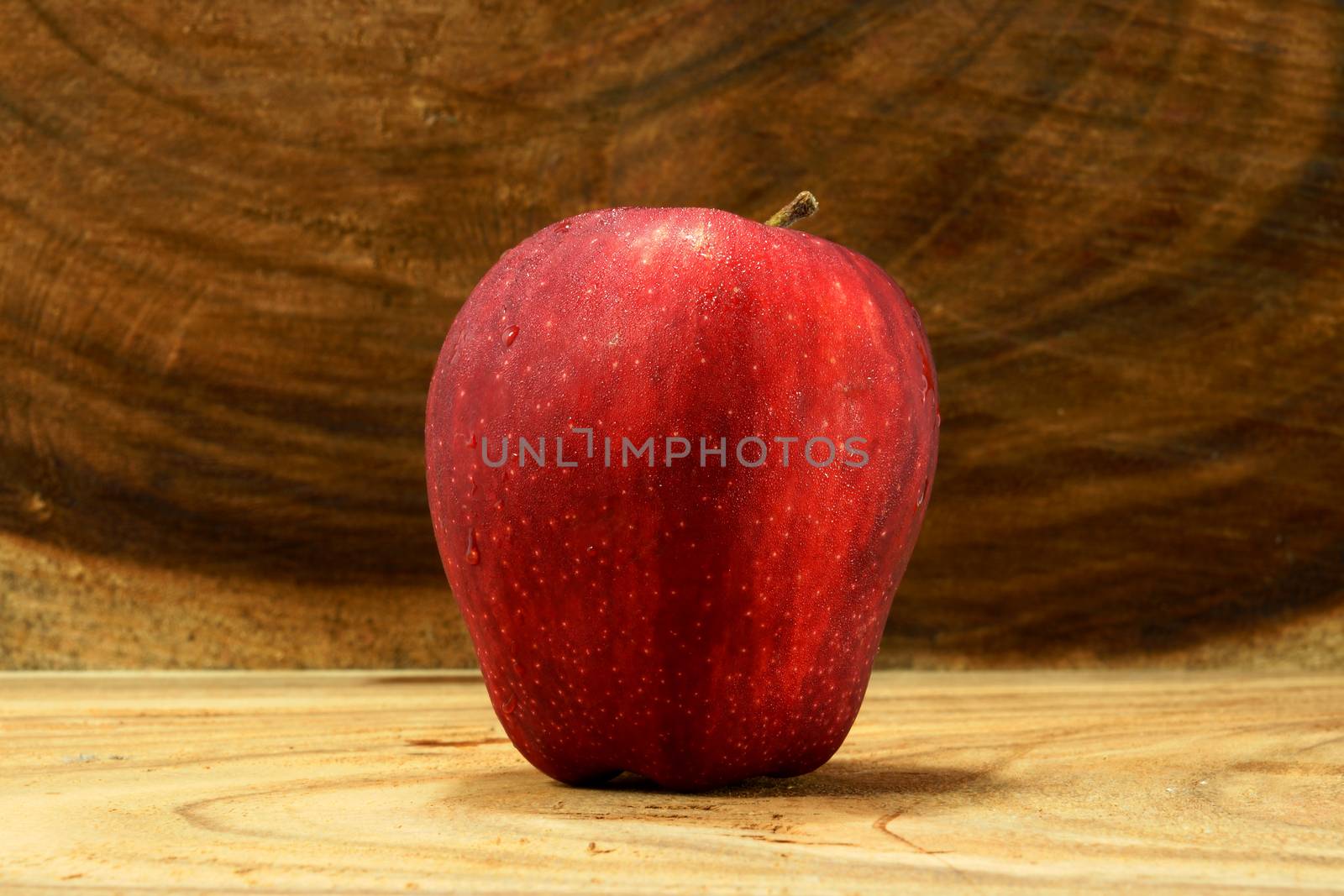 Red apple on wood background.