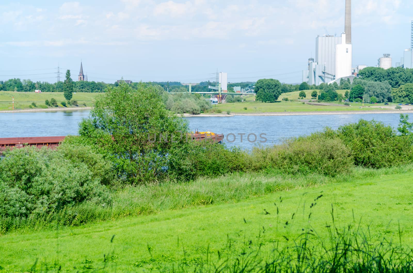 Beautiful Rhine landscape with views of a power plant in a green environment.