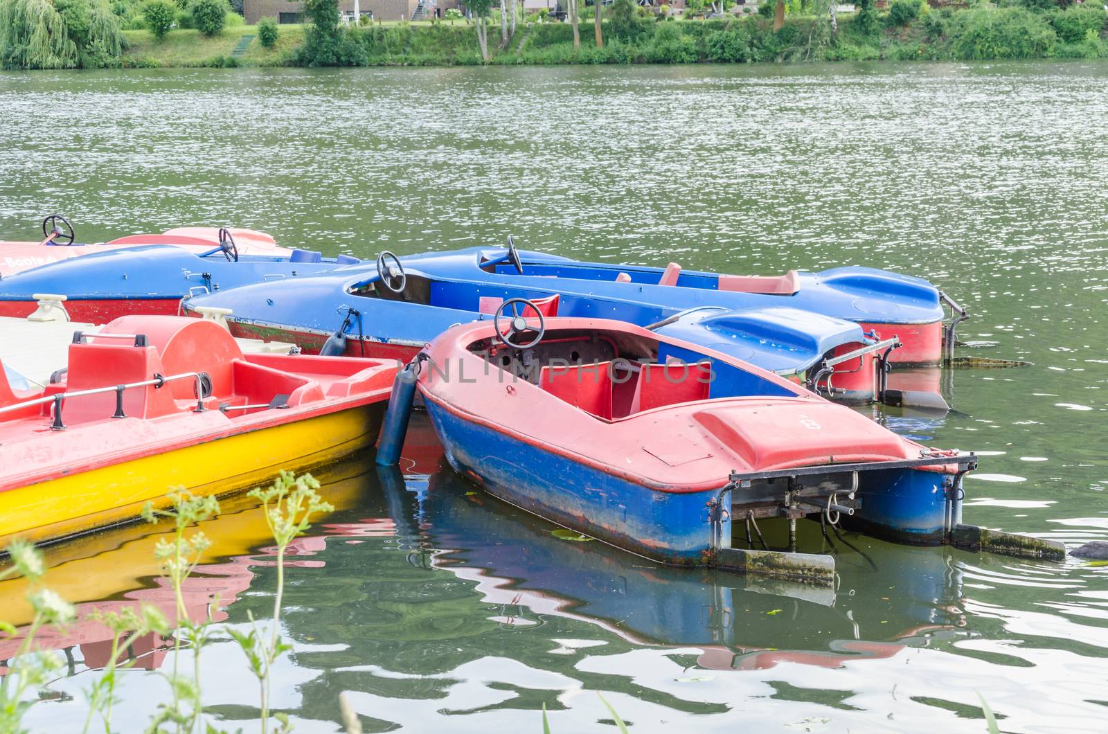 Red blue pedal boats at the dock for hire on the Ruhr reservoir in Essen Kettwig