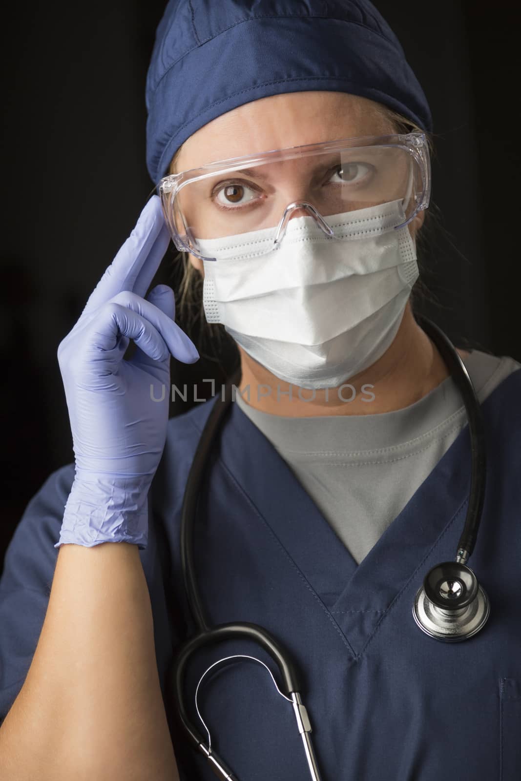 Concerned Female Doctor or Nurse Wearing Protective Facial Wear and Surgical Gloves.