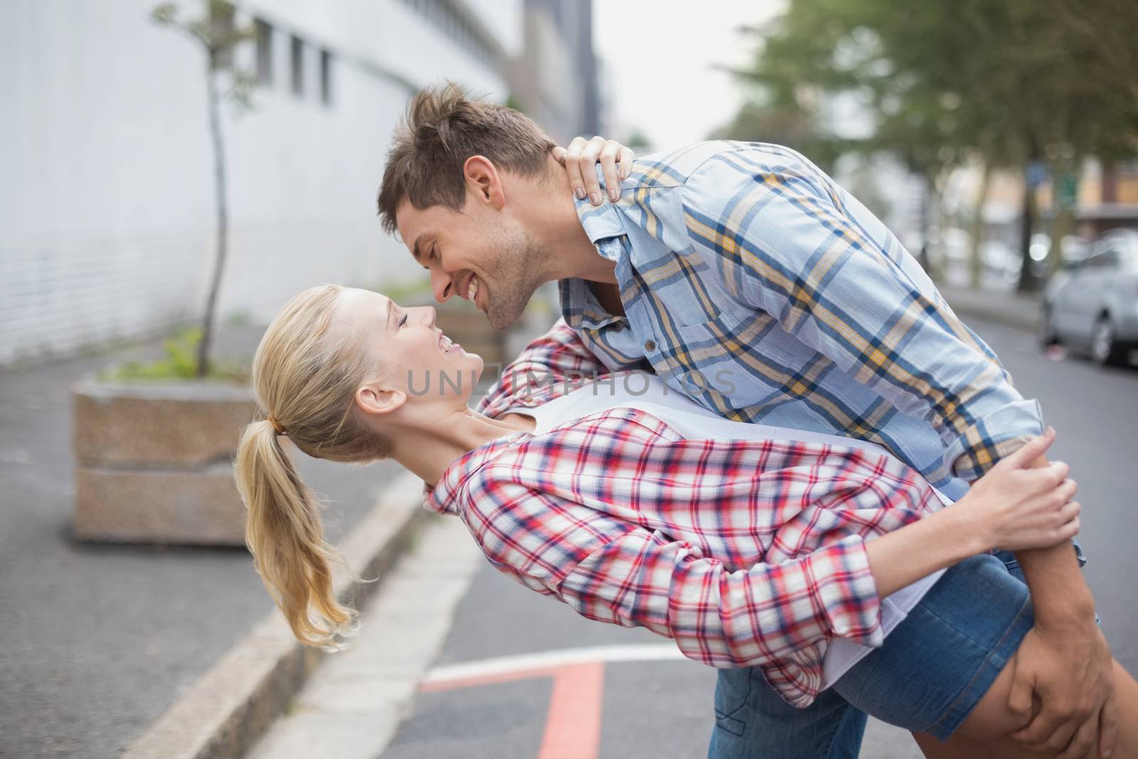 Hip romantic couple dancing in the street on a sunny day in the city