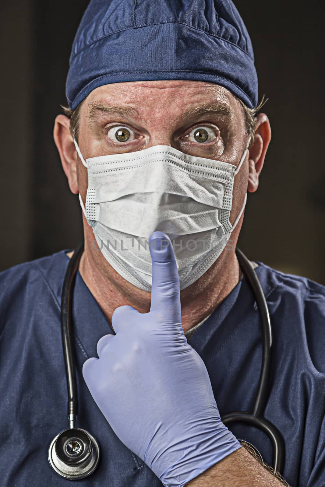 Stunned Doctor or Nurse With Finger in Front of Mouth wearing Protective Wear and Stethoscope.
