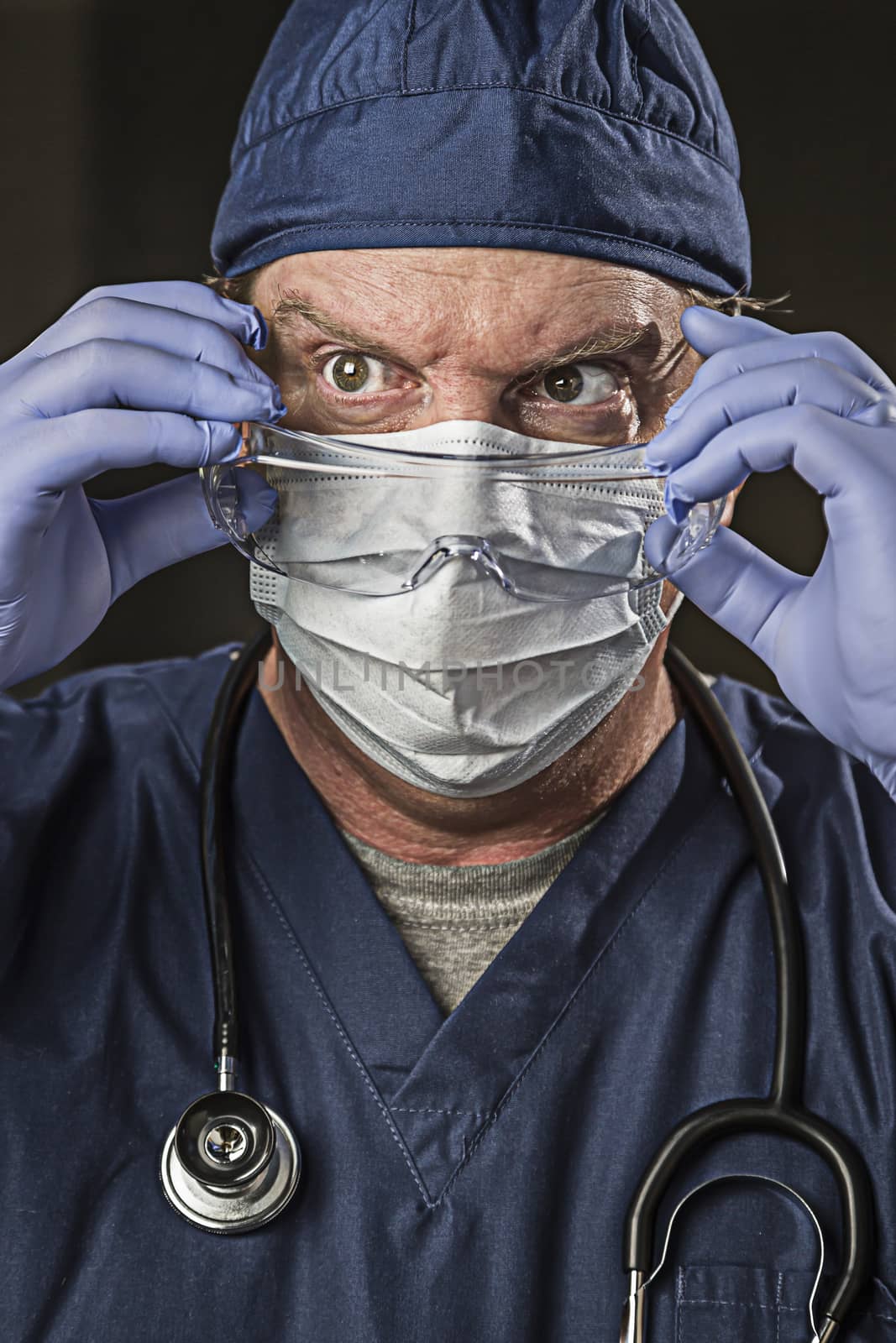 Determined Looking Male Doctor or Nurse with Protective Wear and Stethoscope.