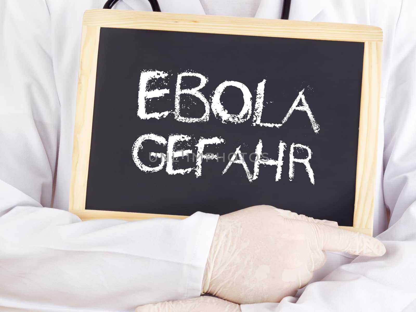 Doctor shows information: Ebola risk in german language by gwolters