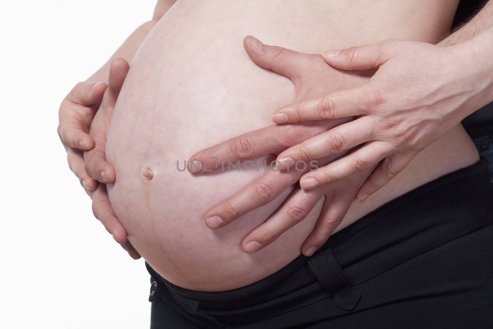 closeup of a pregnant woman touching her belly - isolated on white