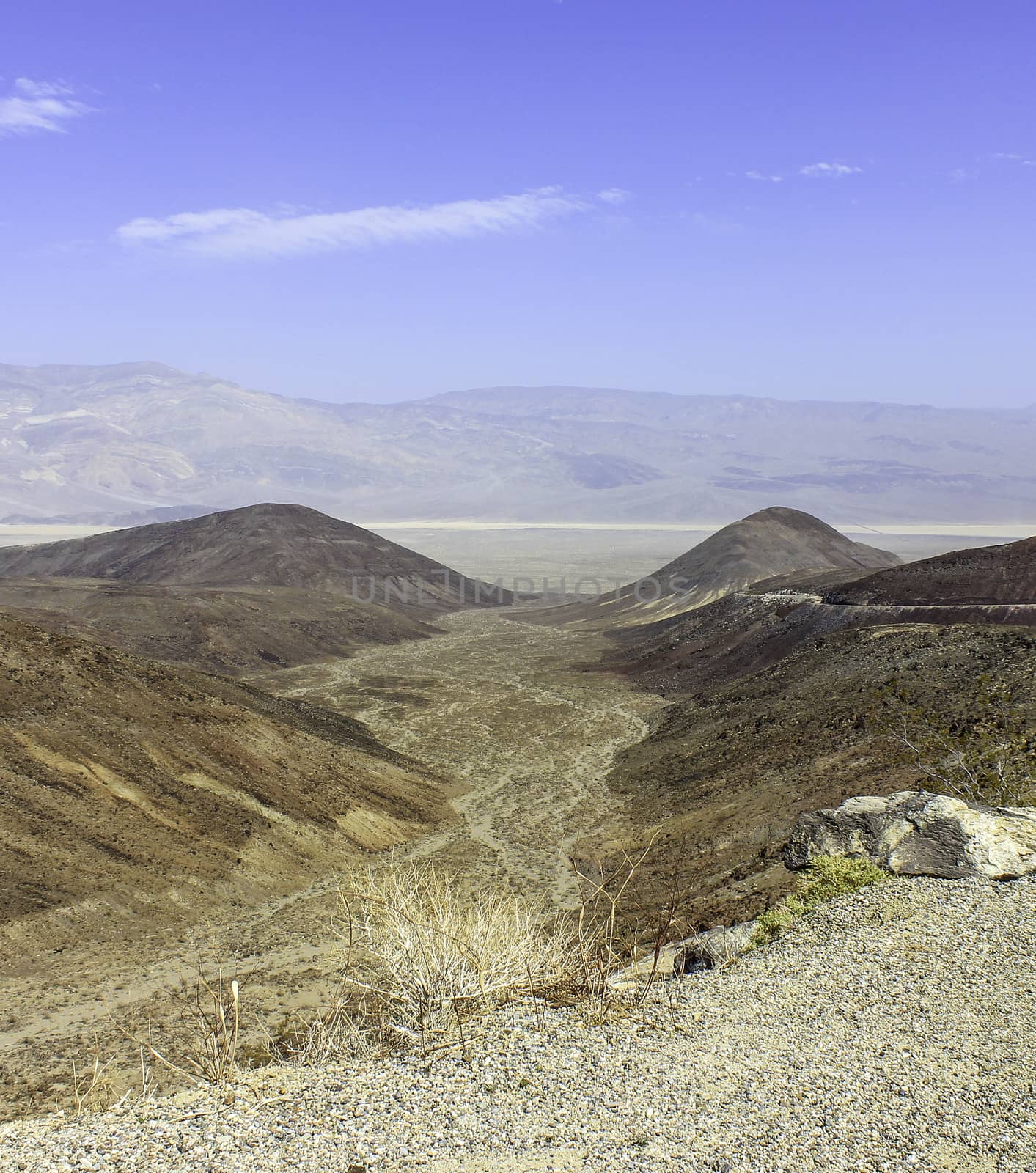 Looking down on an alluvial fan with desert and mountains in the distance
