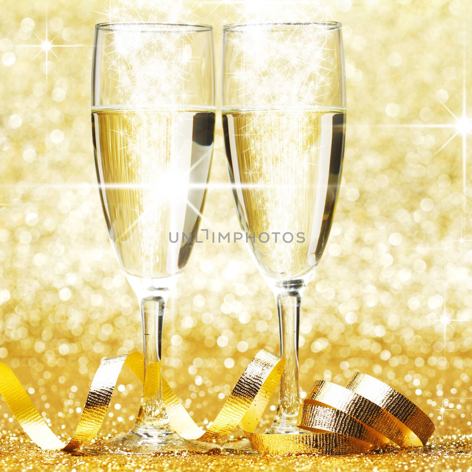 Glasses of champagne and ribbon on golden glitters