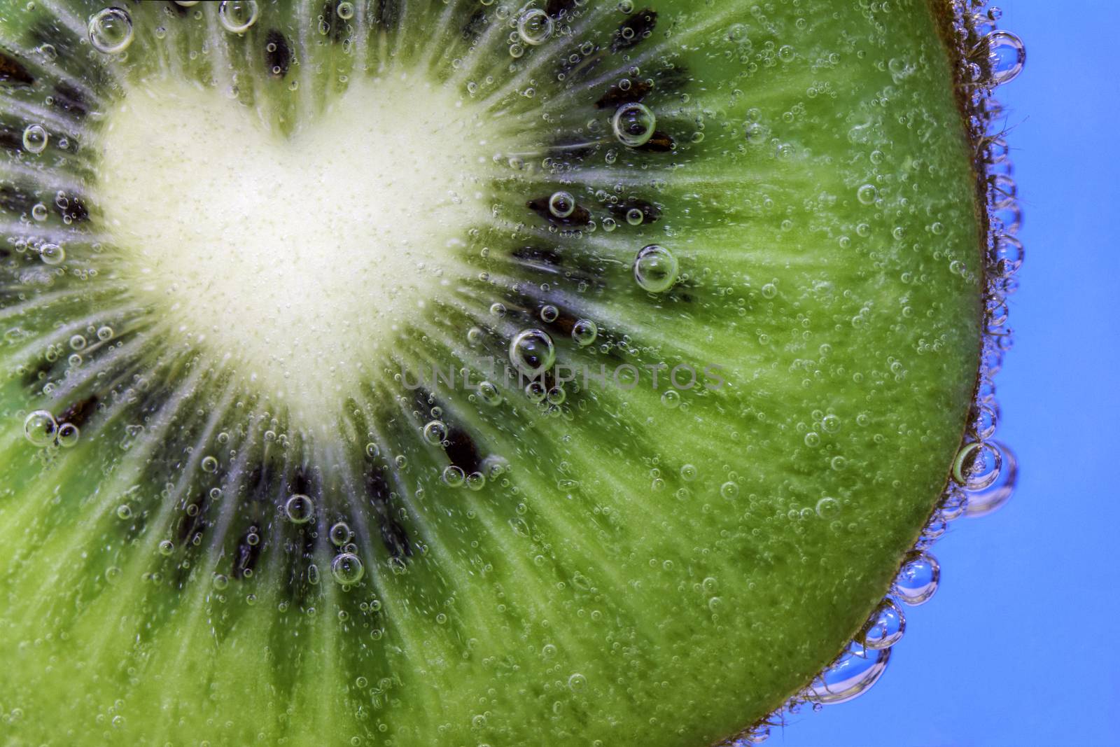 Closeup of a heart shaped kiwi slice covered in water bubbles