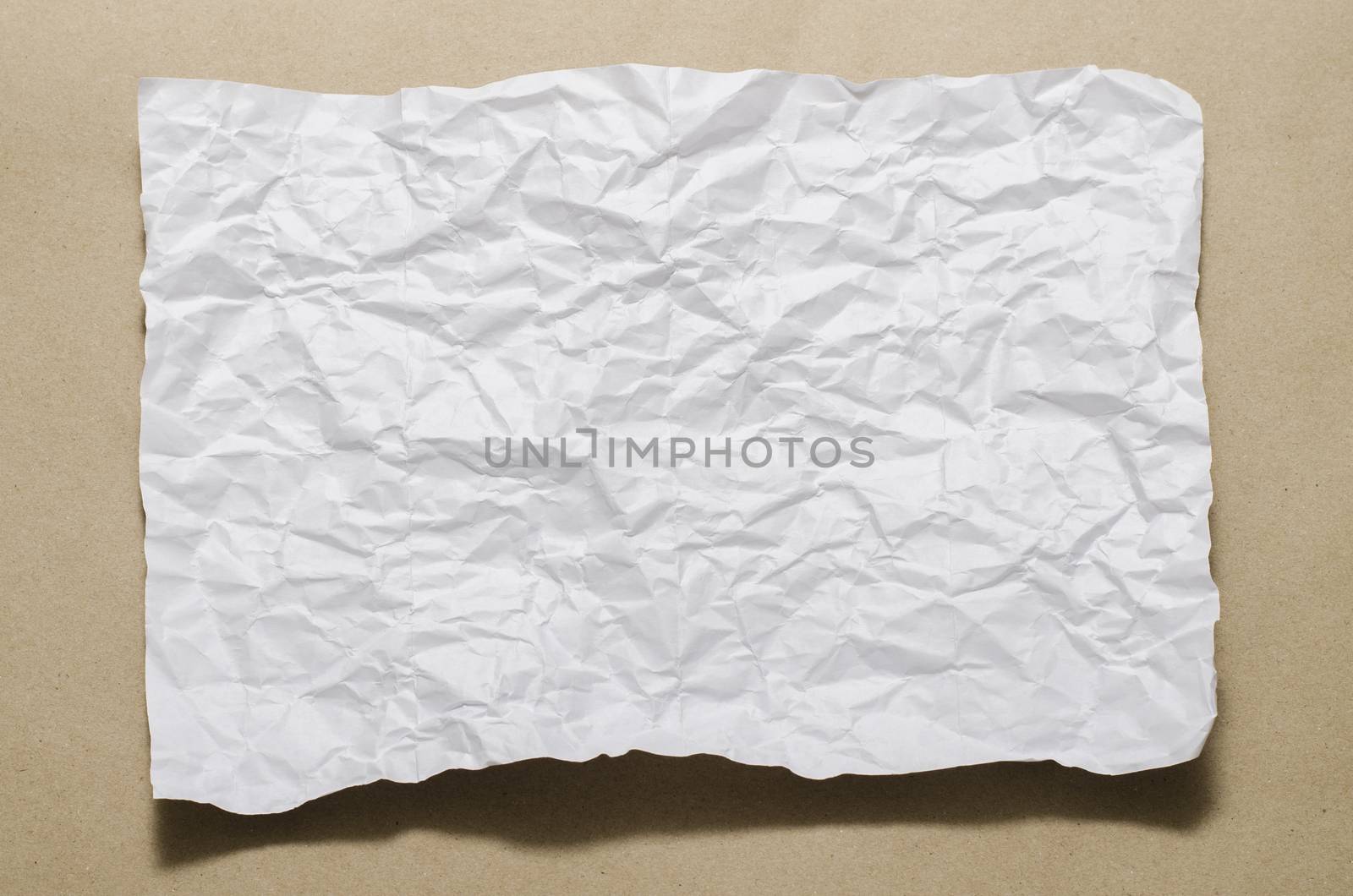 a4 size white crumpled paper on brown color background