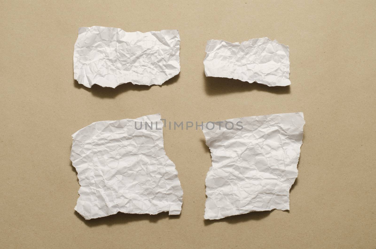 piece of white crumpled paper on brown background