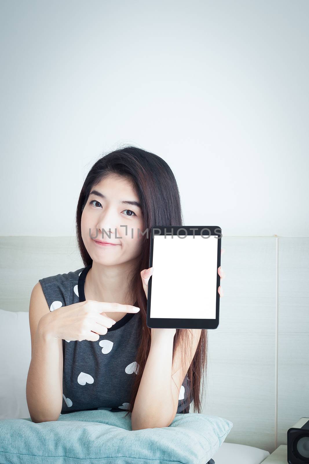 Young Asian woman show or display tablet with white blank screen by FrameAngel
