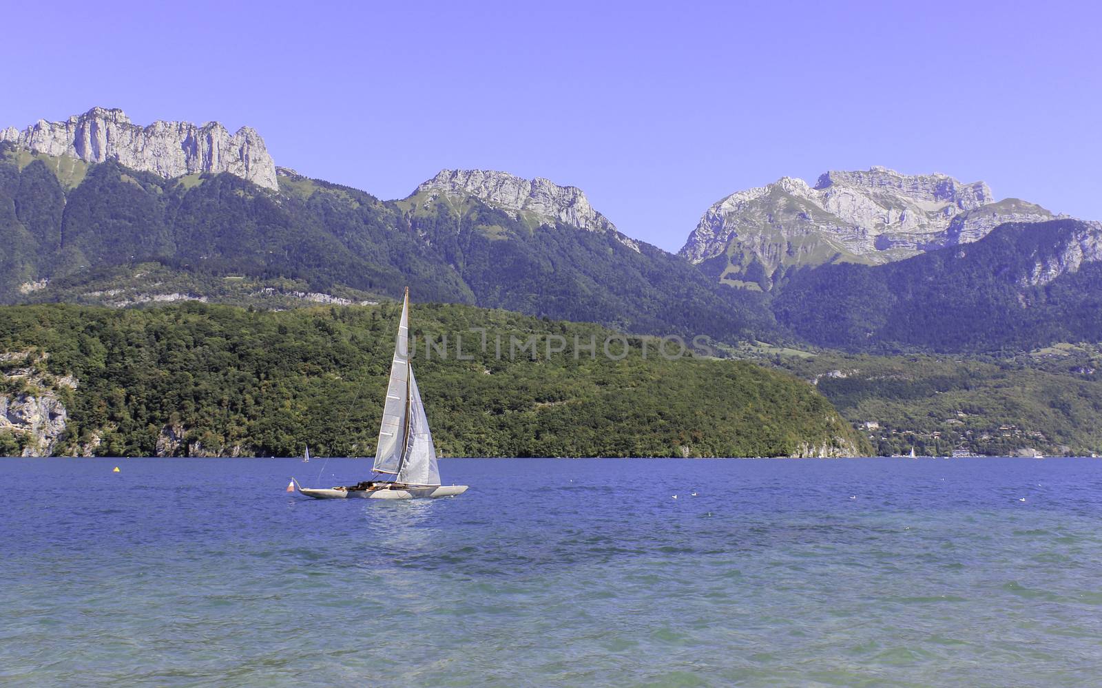 A sailing boat on a stunning blue lake with a fabulous mountainous backdrop