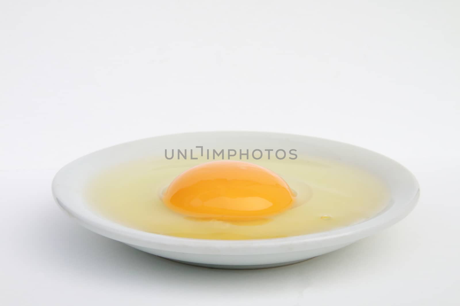 raw egg in the plate by kaidevil