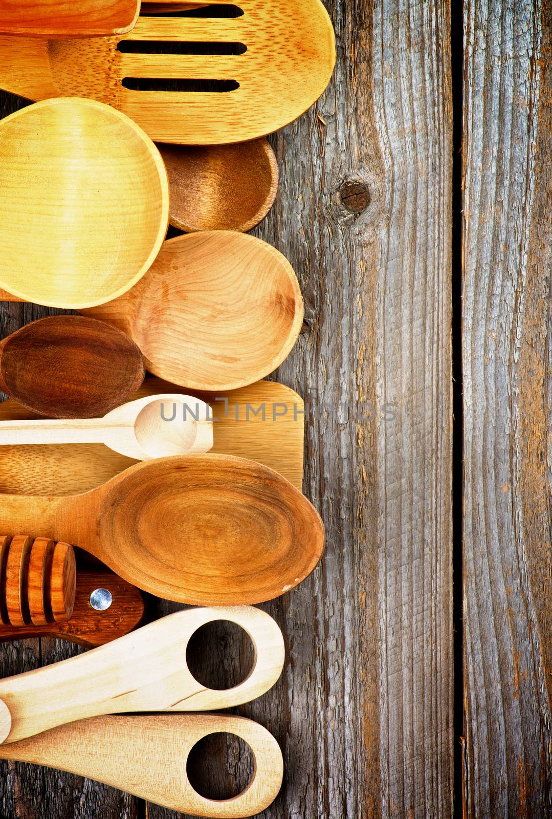 Border of Various Wooden Spoons and Cooking Utensils isolated on Rustic Wooden background