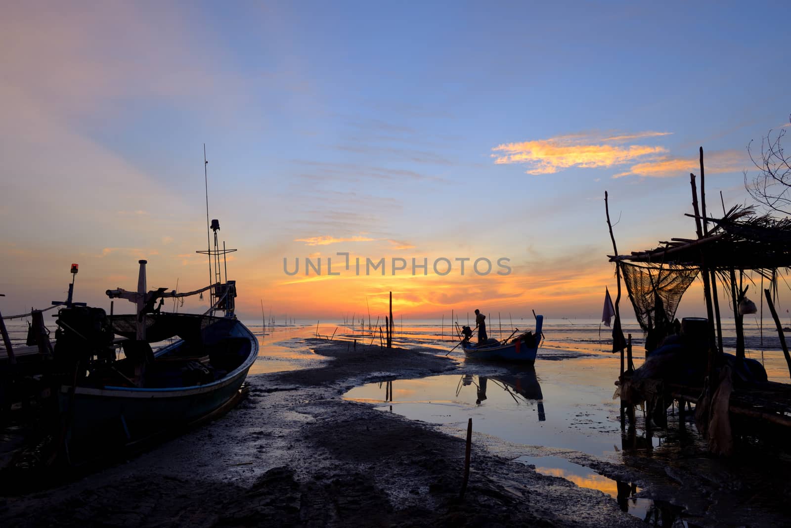 Fisherman is standing on fishing boat to back home in the morning at thailand