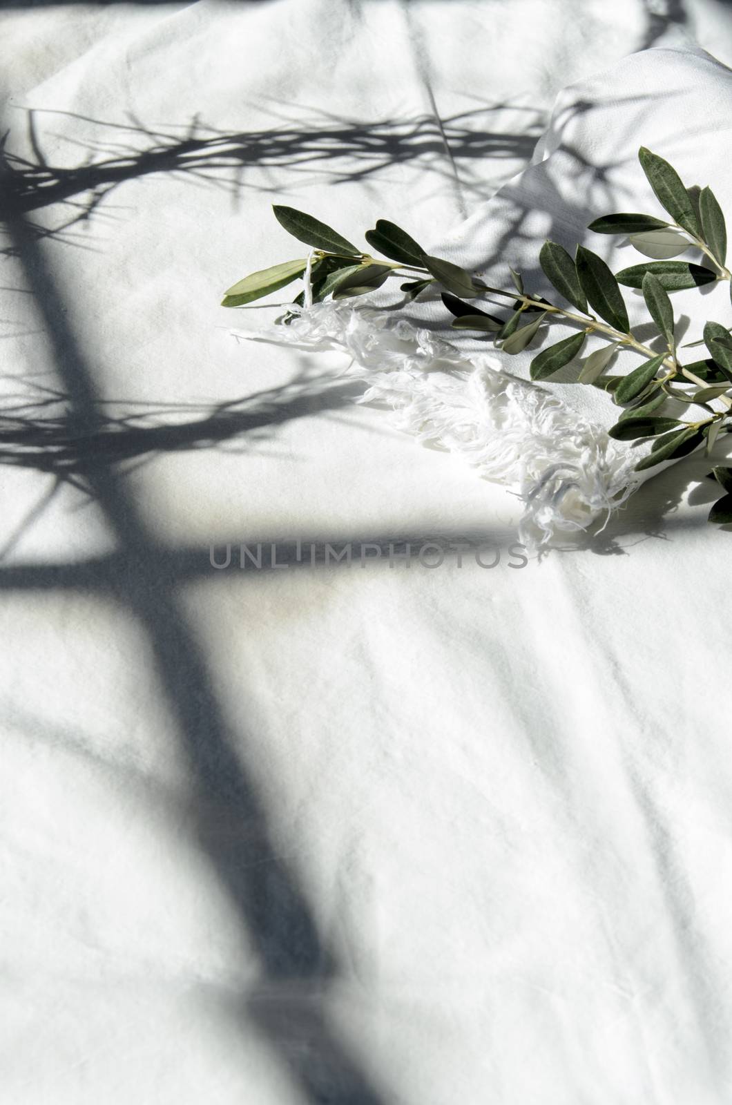 crown of thorns reminds the passion of the christ. resting on a white linen cloth with an olive branch