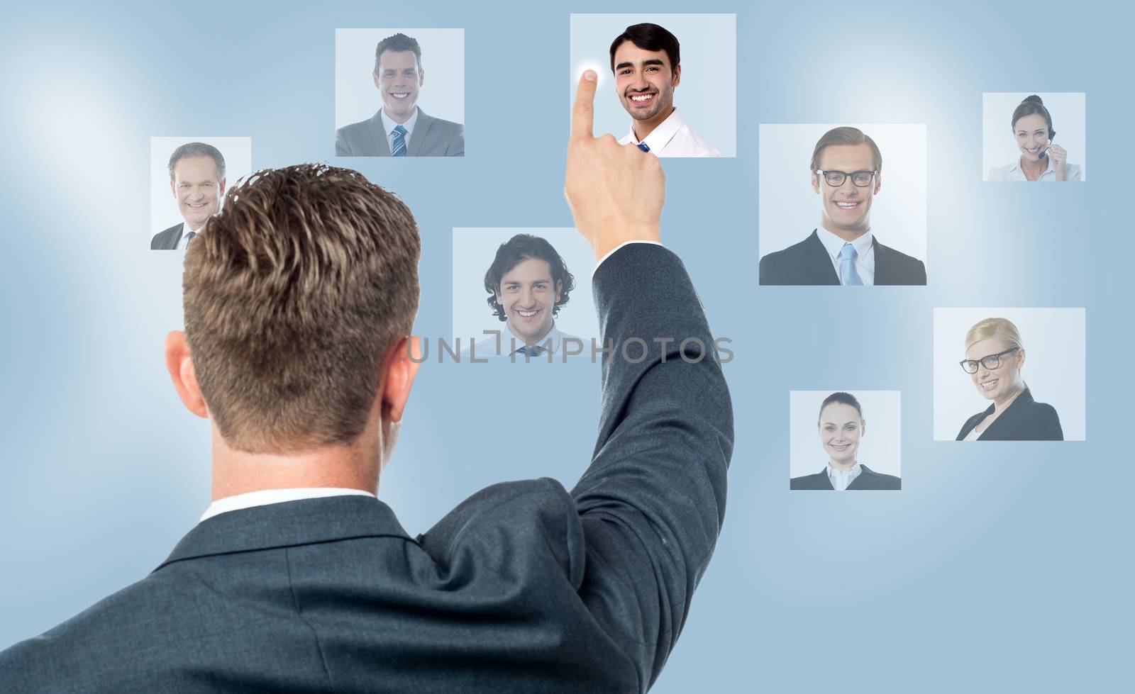 Rear view of man pointing coworkers picture on screen