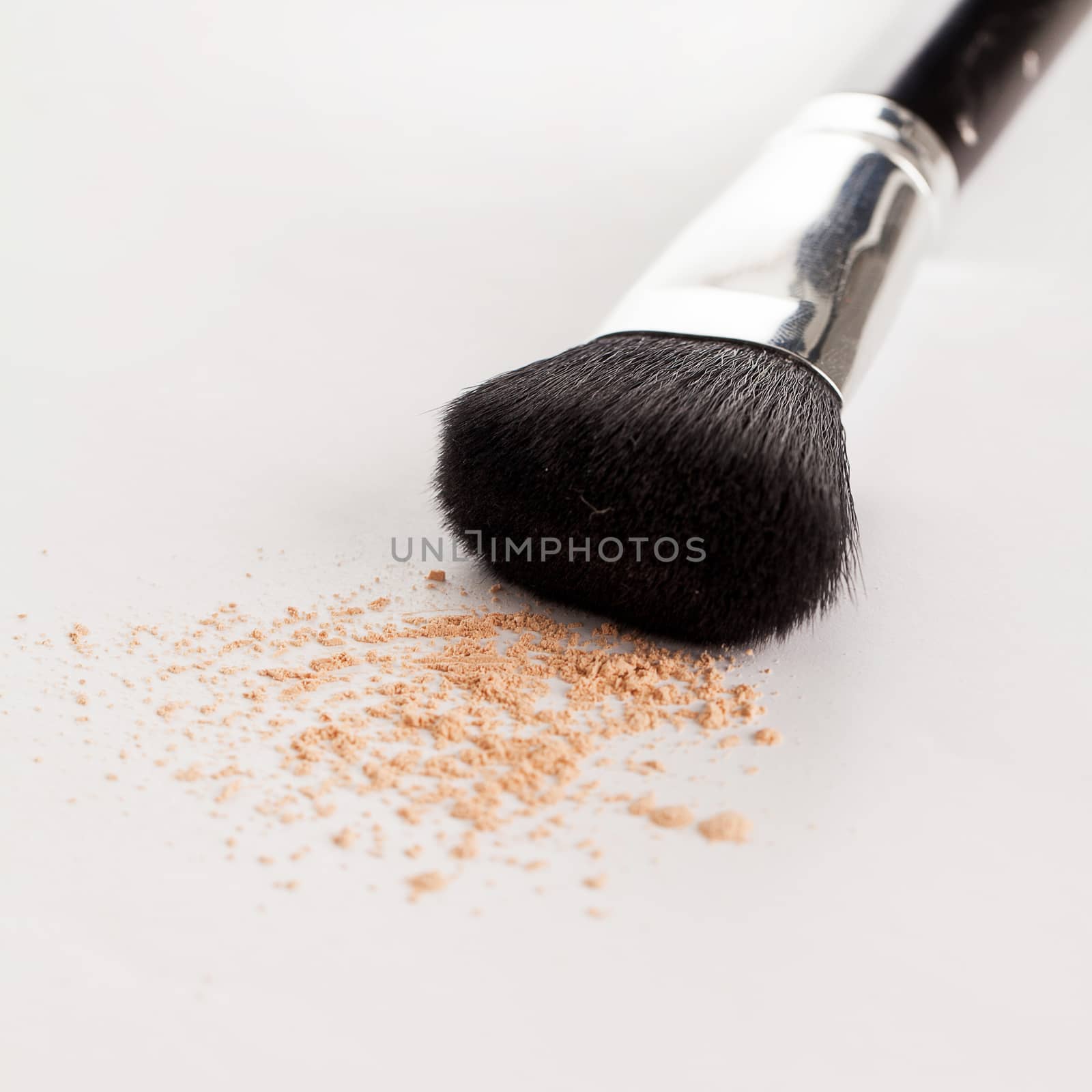 Makeup natural brush with beige powder on a white background