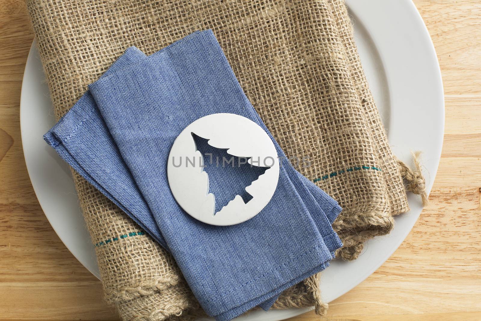 Plastic tree shaped biscuit cutter on blue napkin.