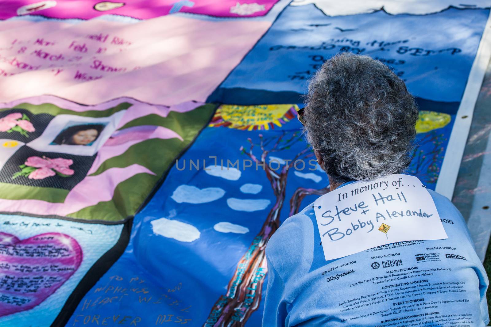 Woman Viewing Section of AIDS Quilt by Creatista