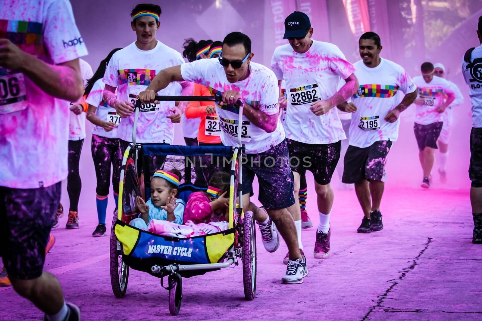 Ventura, CA - OCTOBER 18 : Participants coming through the pink color station at The Color Run 2014 in Ventura. OCTOBER 18, 2014 in Ventura, CA.