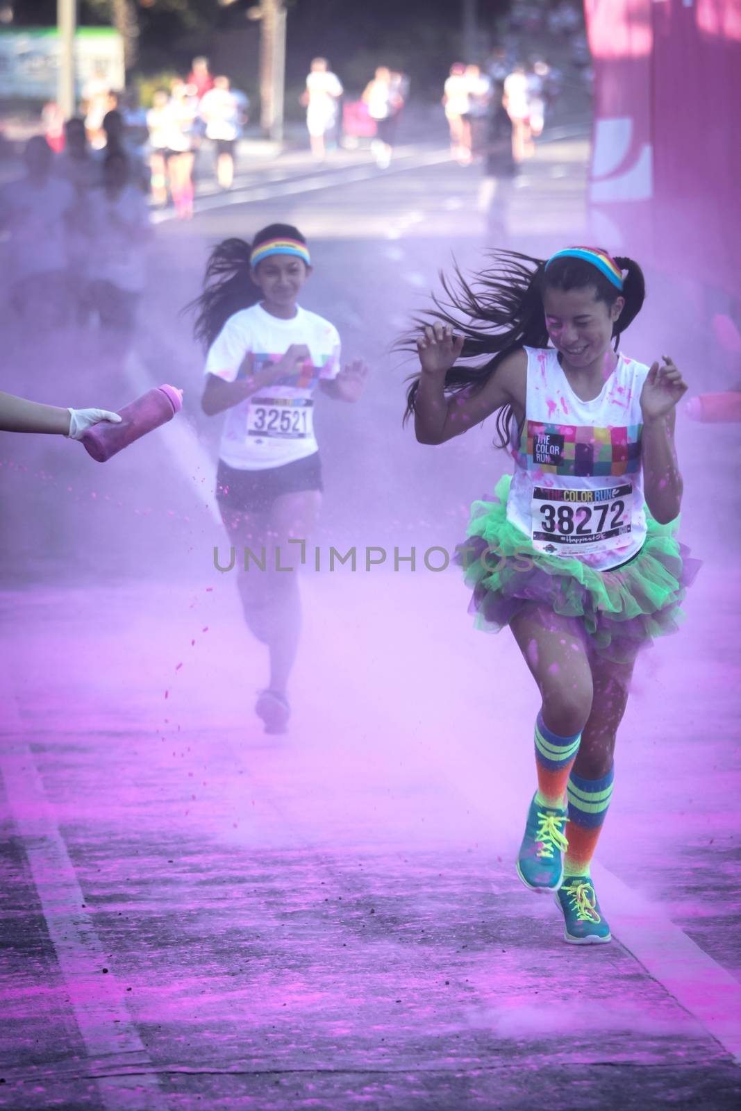 Ventura, CA - OCTOBER 18 : Participants coming through the pink color station at The Color Run 2014 in Ventura. OCTOBER 18, 2014 in Ventura, CA.