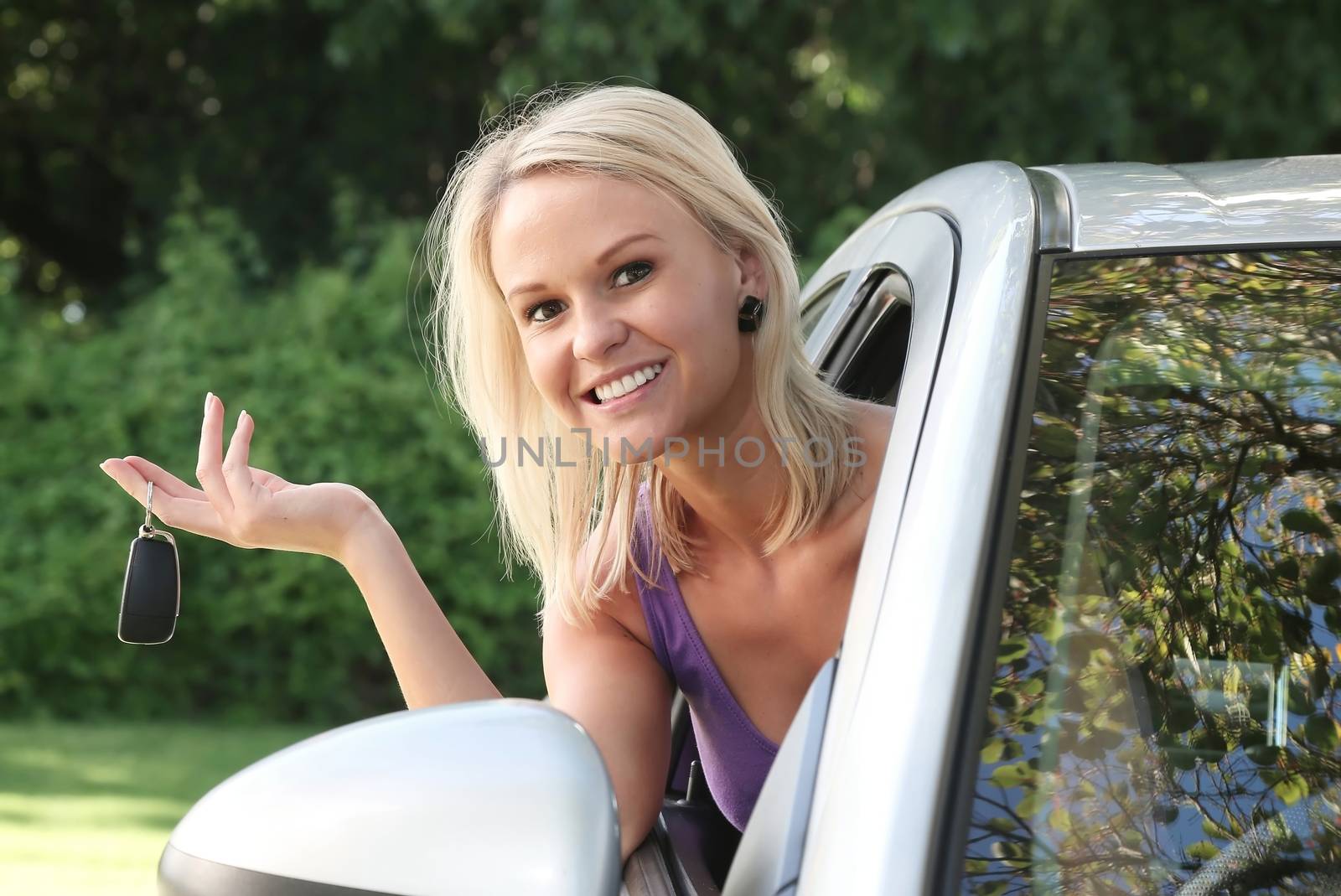 Lovely smiling young woman with the key to her new vehicle