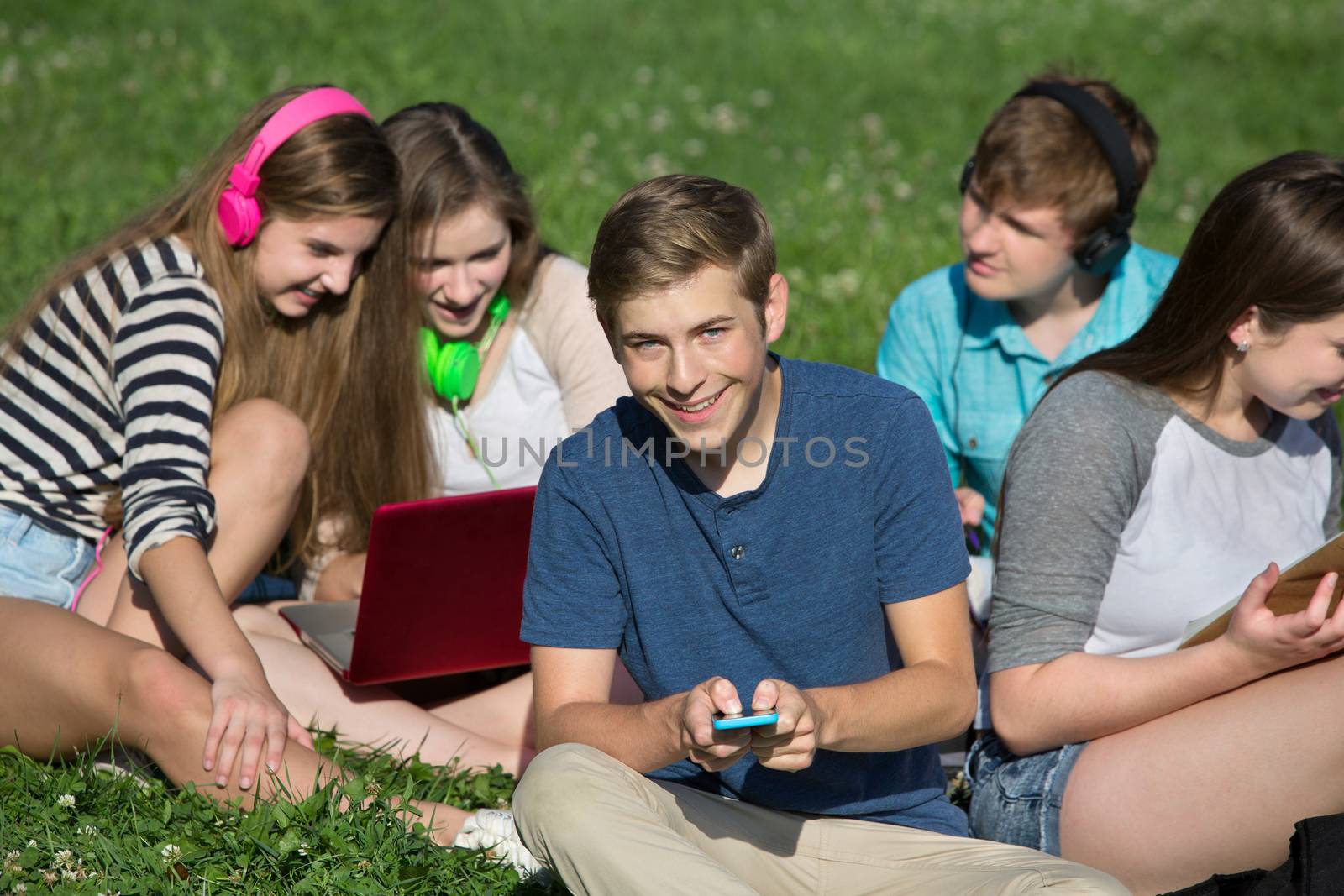 Group of cheerful students texting and studying