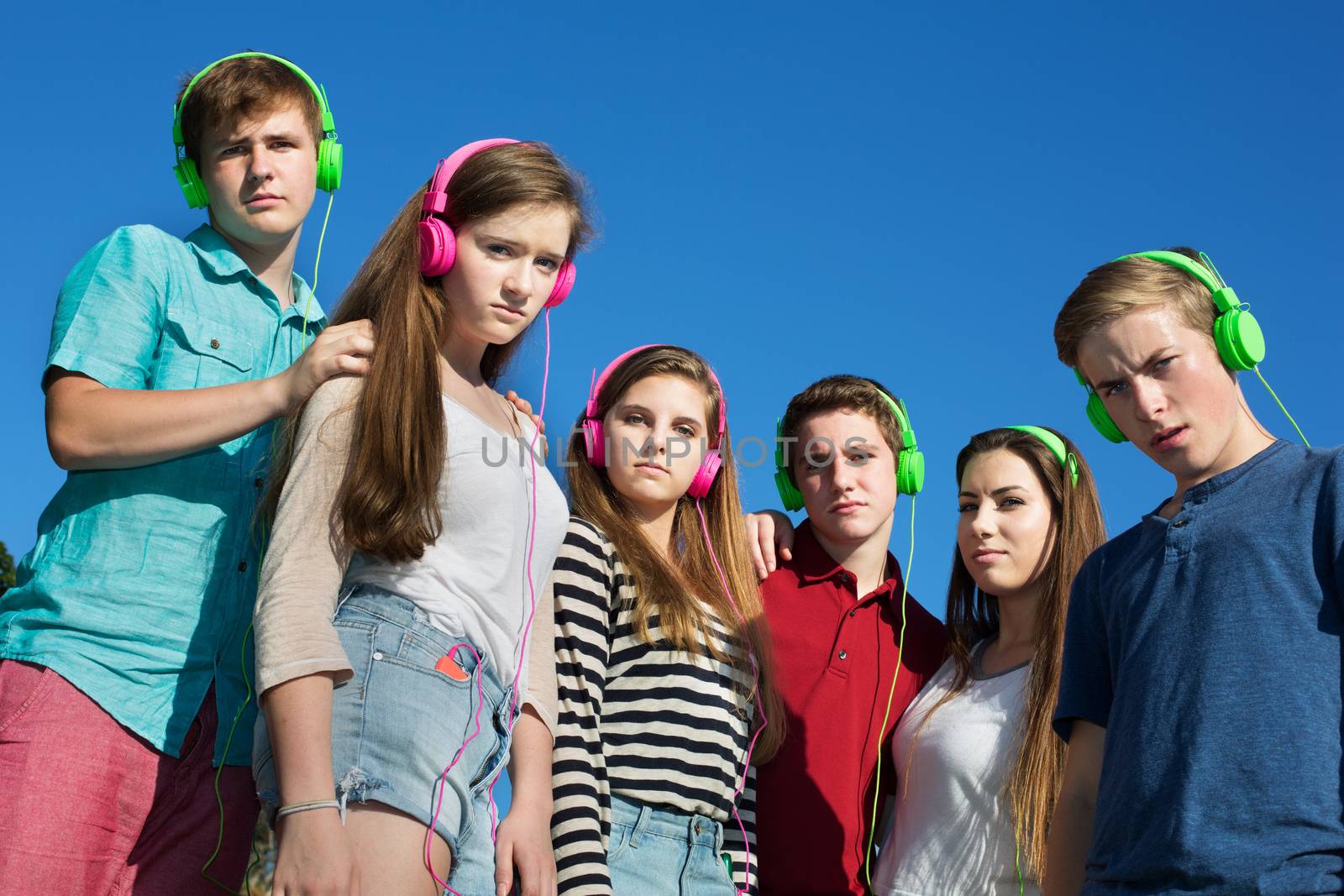 Group of offended teens in pink and green headphones