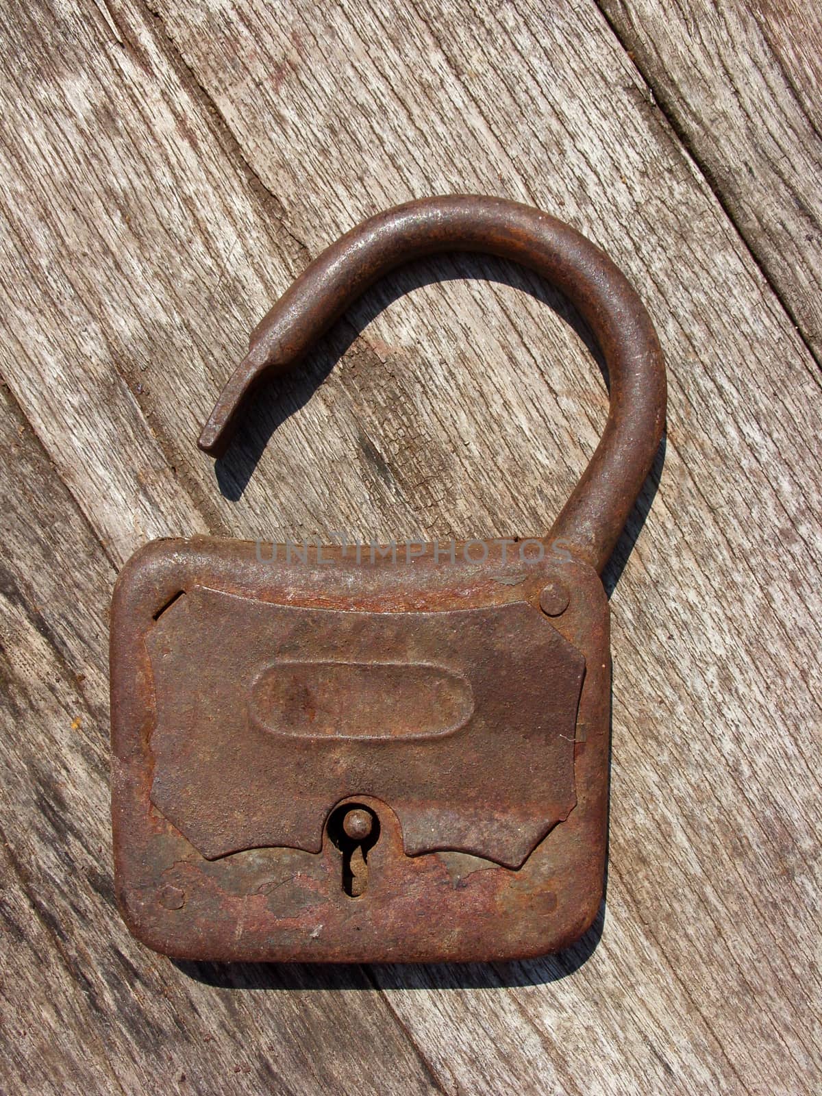 Old rusty padlock on wooden background