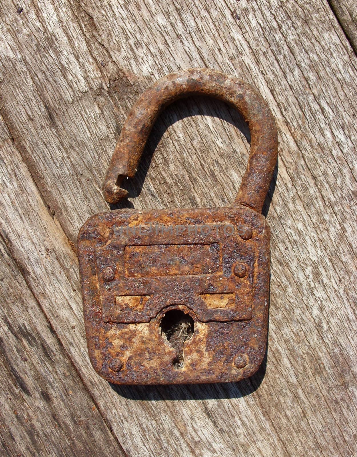 Old rusty padlock on wooden background