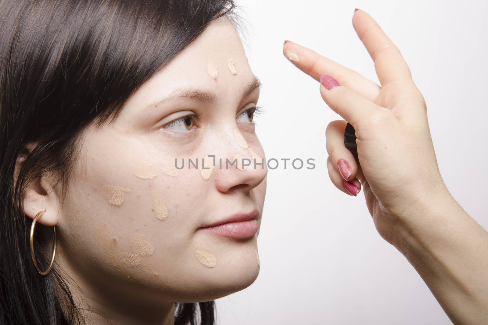  Makeup artist puts makeup model. She pointwise causes Foundation on the person then rubs evenly on the face model