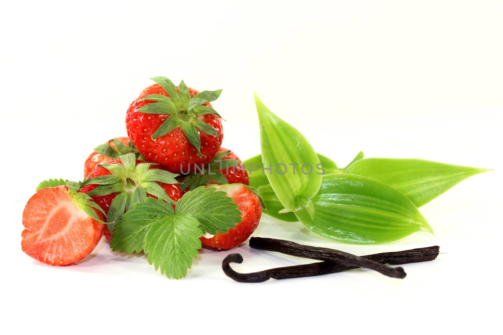 a vanilla bean with vanilla leaves and fresh strawberries