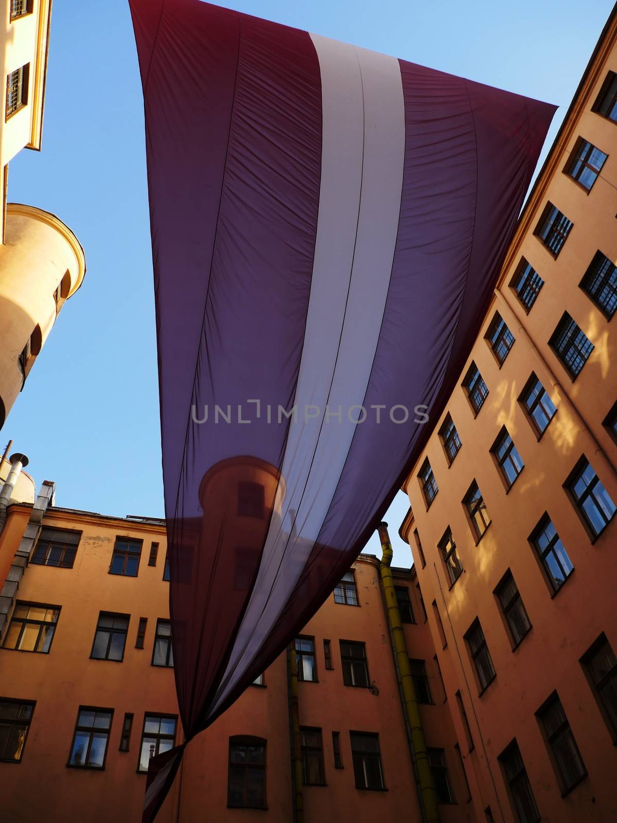 Huge Latvian Flag between old buildings in Old town