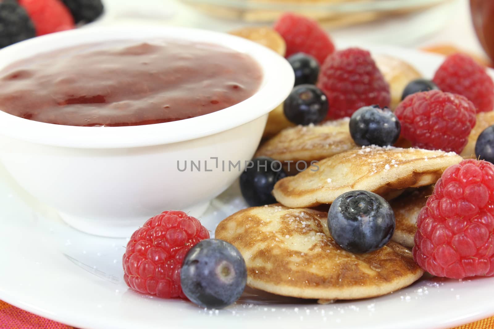 Dutch Poffertjes with fresh berries before light background