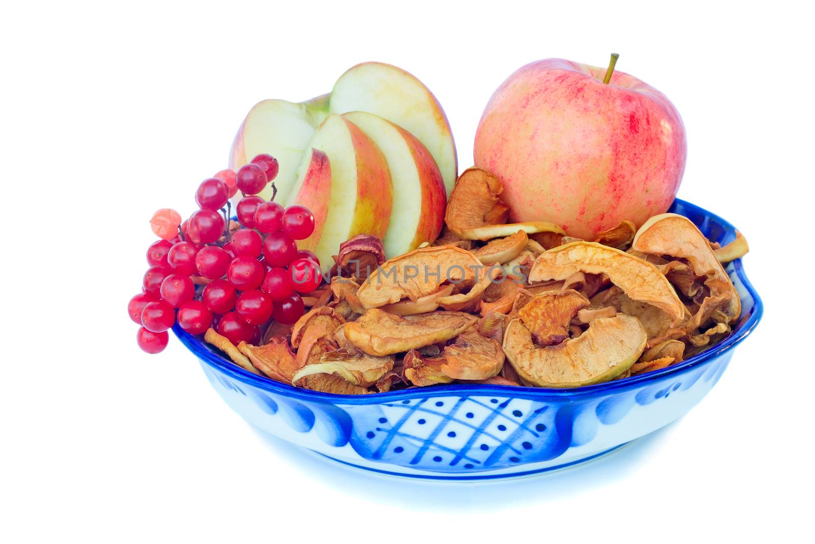 Fresh apples, the dried-up segments of apples and berry of a guelder-rose in a ceramic vase on a white background.