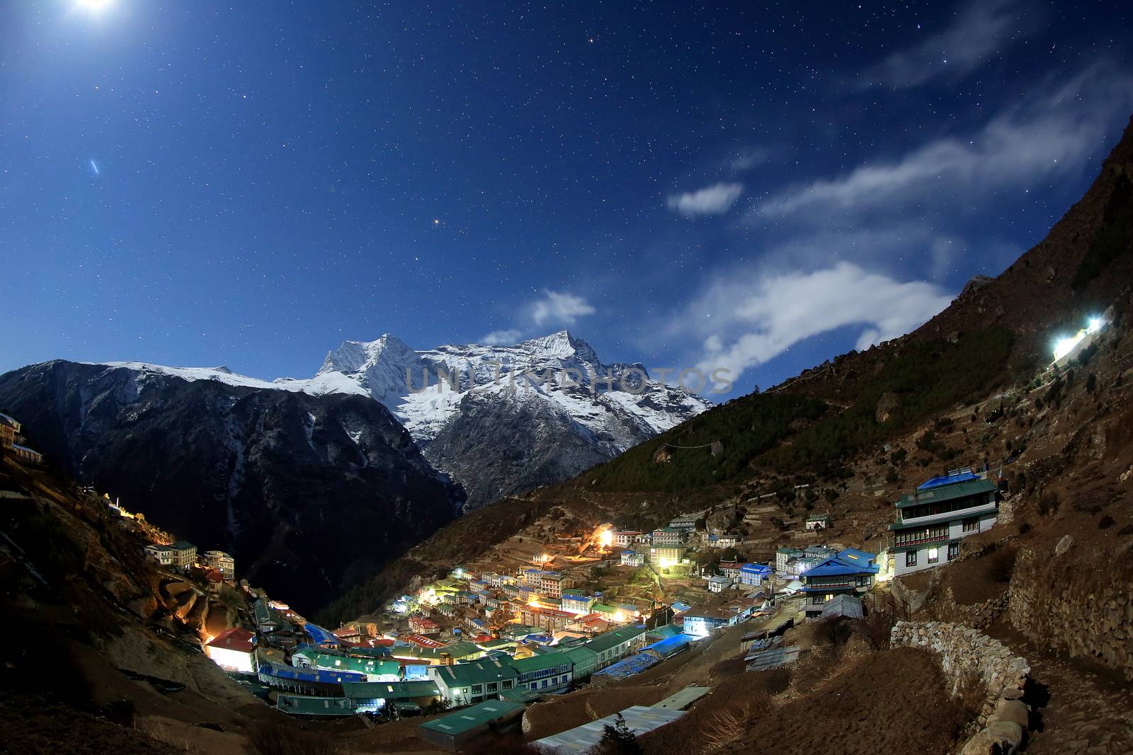 Night sky and stars passing by behind mountain Kongde Ri, Namche Bazaar village. Nepal.
