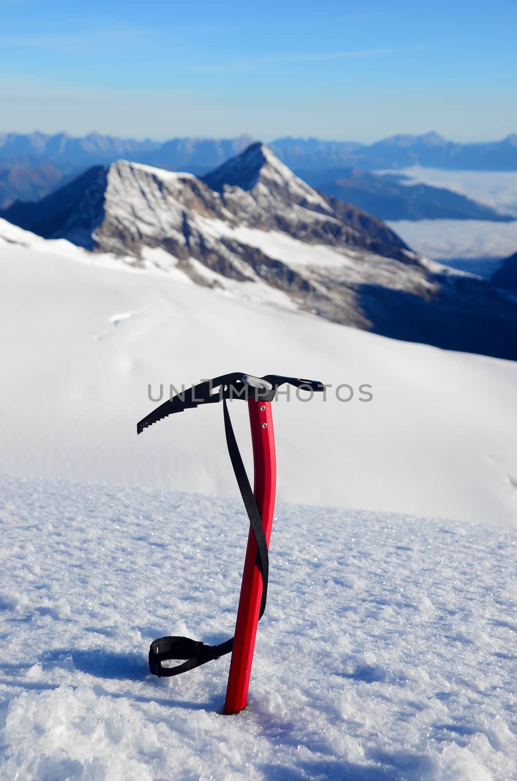 Ice ax stuck in the snow high in the mountains above the glacier