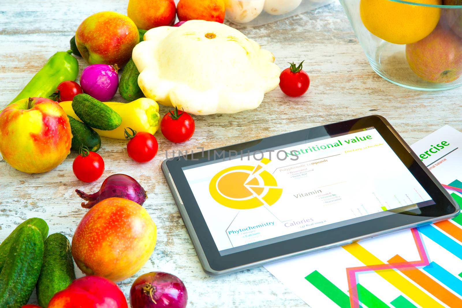 Organic food and a Tablet PC showing information about healthy nutrition and phytochemical composition.